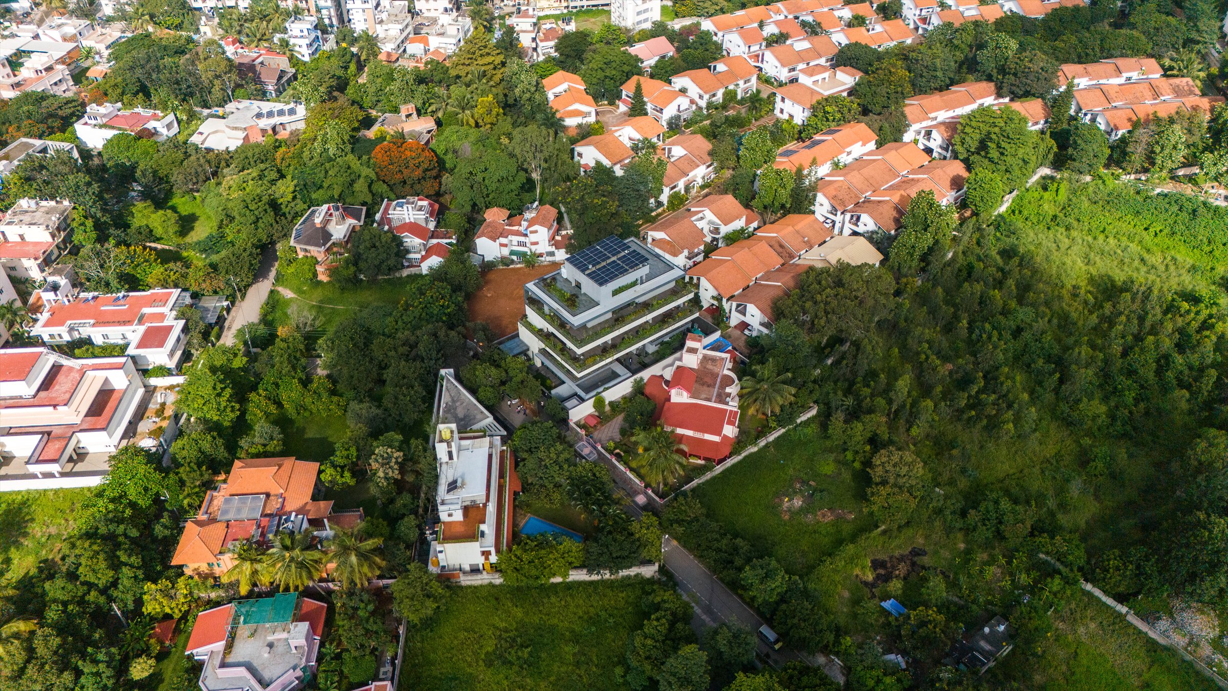 Aerial view of The Stepped Haven with its planted terraces among tiled-roof houses