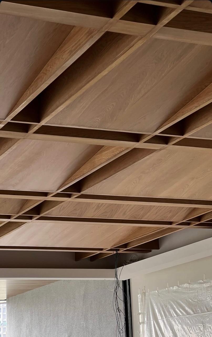 Coffered oak ceiling with deep crossing beams, photographed during construction
