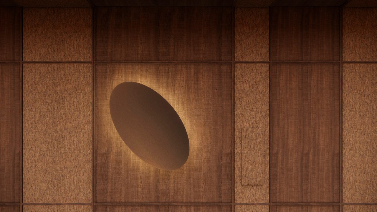 Recessed oval wall light glowing within walnut and woven-fabric wall panels