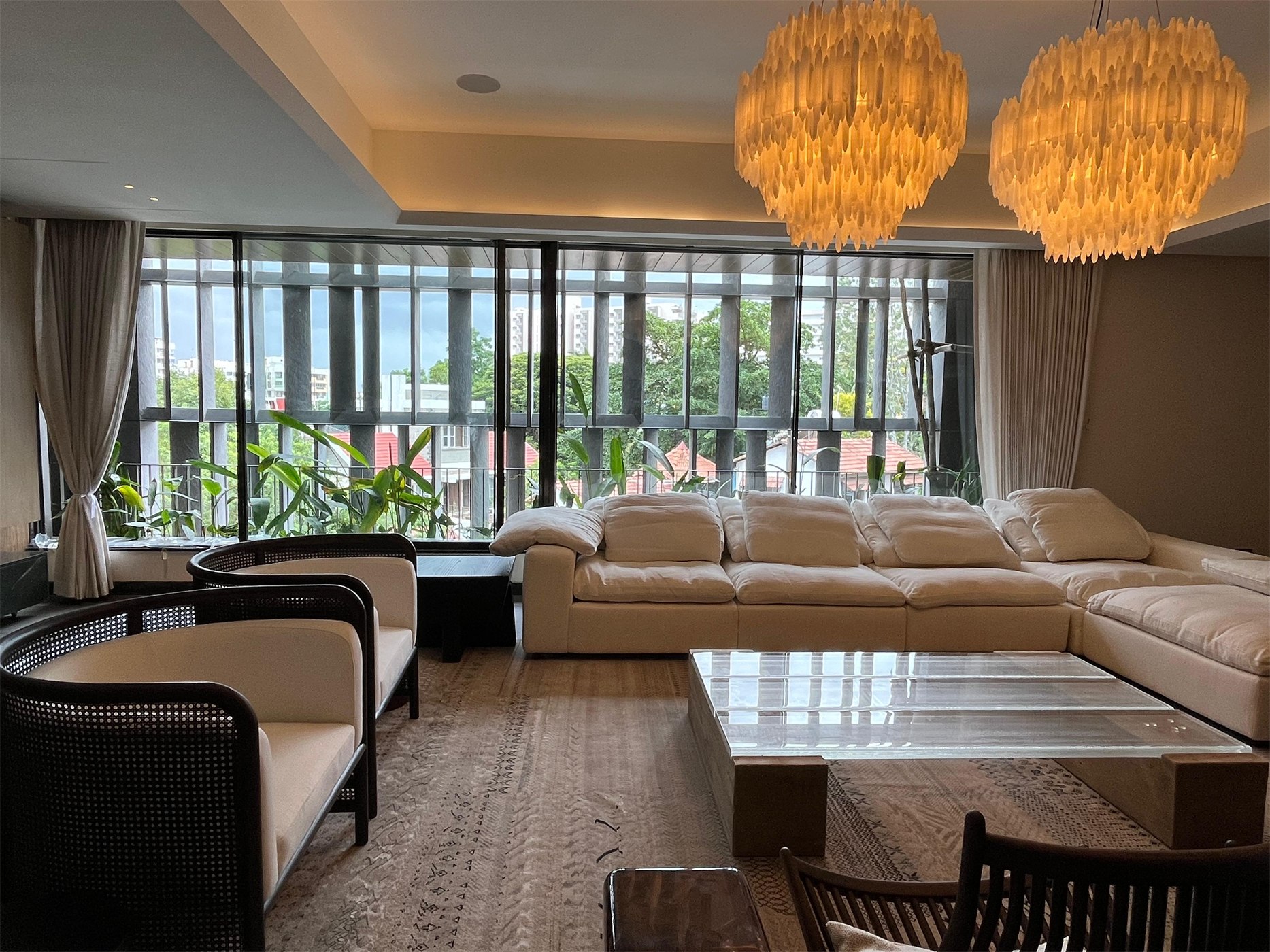 Formal living room at The Stepped Haven with alabaster chandeliers and cane armchairs before the louvred façade
