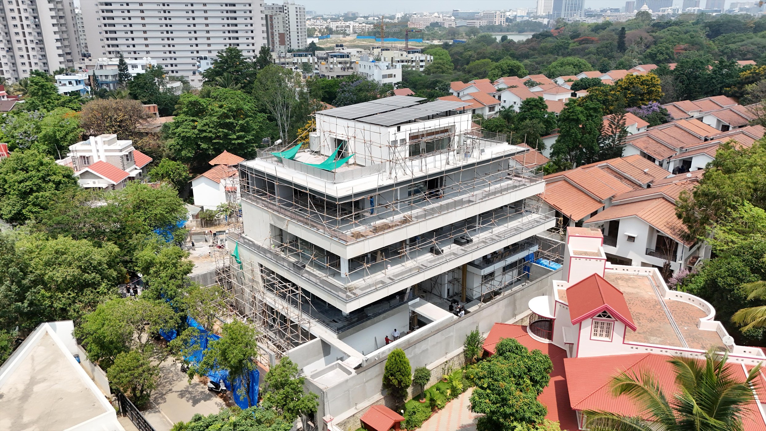 Aerial view of The Stepped Haven nearing completion, wrapped in scaffolding among the surrounding houses