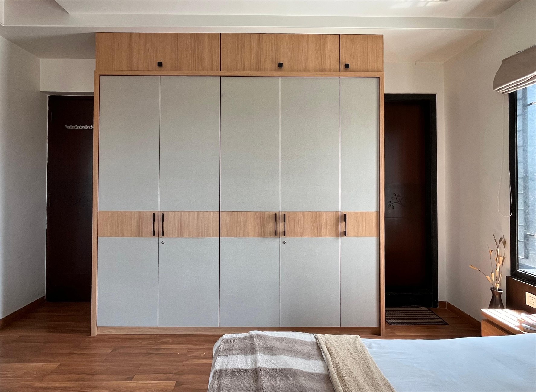 The Hideout as built: the finished wardrobe with light grey shutters and an oak band of handles