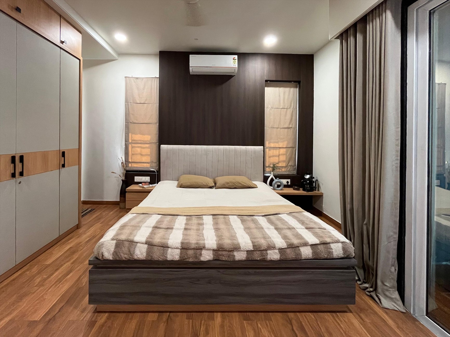 The Hideout as built: the bed centred on the dark timber wall between two roman blinds