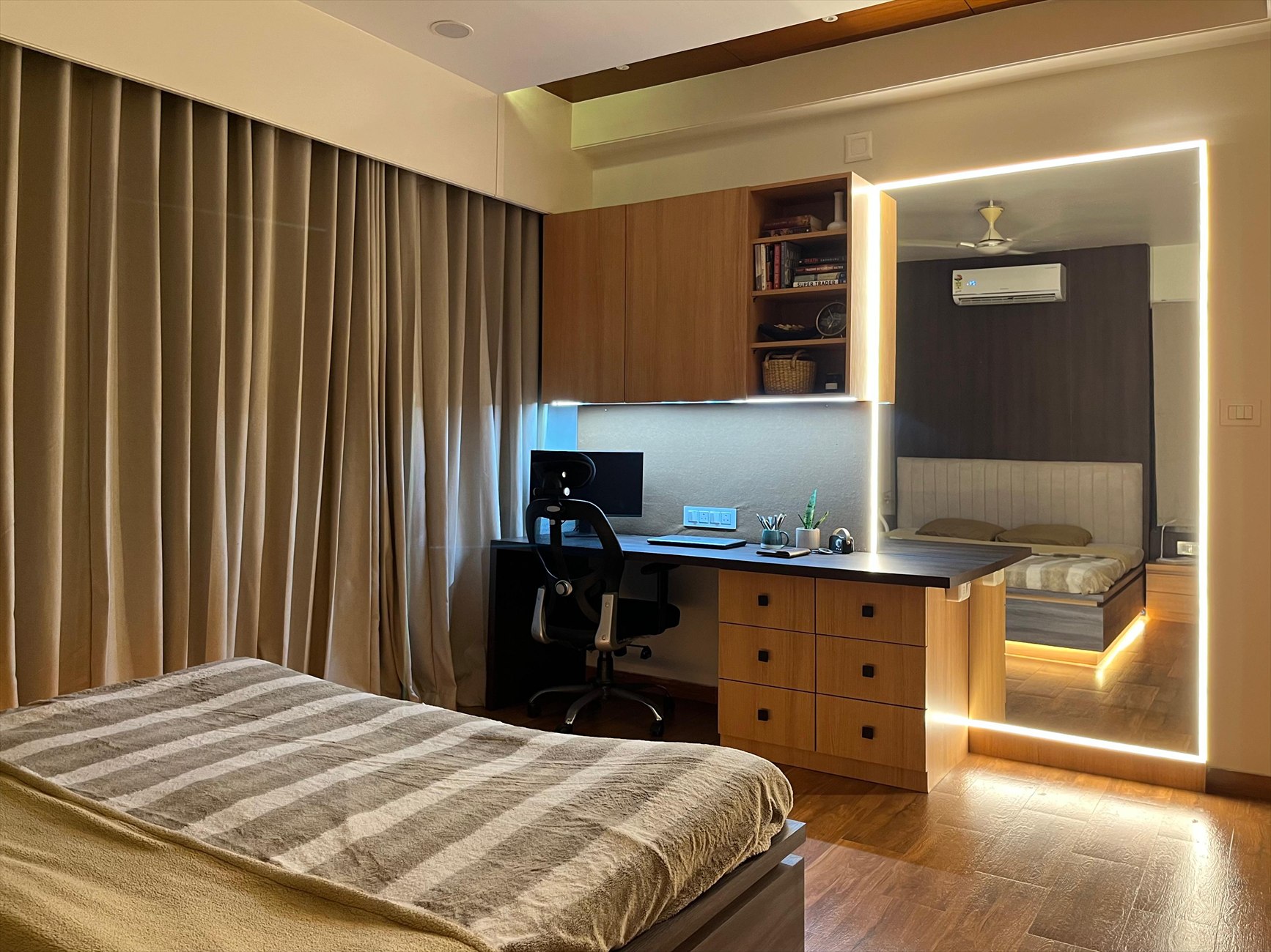 The Hideout as built: the room at night, with the study, lit mirror frame and reflected bed